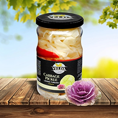 Jar of Velda Cabbage Pickle displayed on a wooden table with a scenic outdoor background.