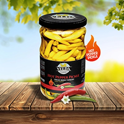 Velda Hot Pepper Pickle jar featured on a wooden table with a sunny outdoor background and a bold 'Hot Pepper Pickle' label.