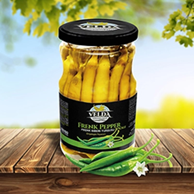 Velda Frenk Pepper Pickle jar presented on a wooden table with a bright outdoor setting.