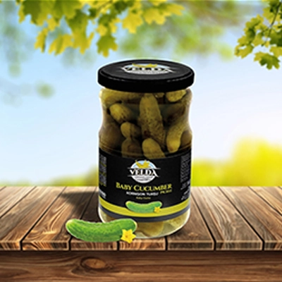 Velda Baby Cucumber Pickle jar showcased on a wooden table with a vibrant outdoor backdrop.